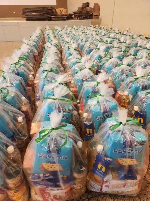 Bolsas navideñas con panetón, aceite y abarrotes listas para entregar